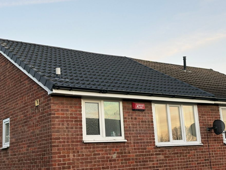 Repaired black roof and roofline on a brick bungalow by AC Roofing