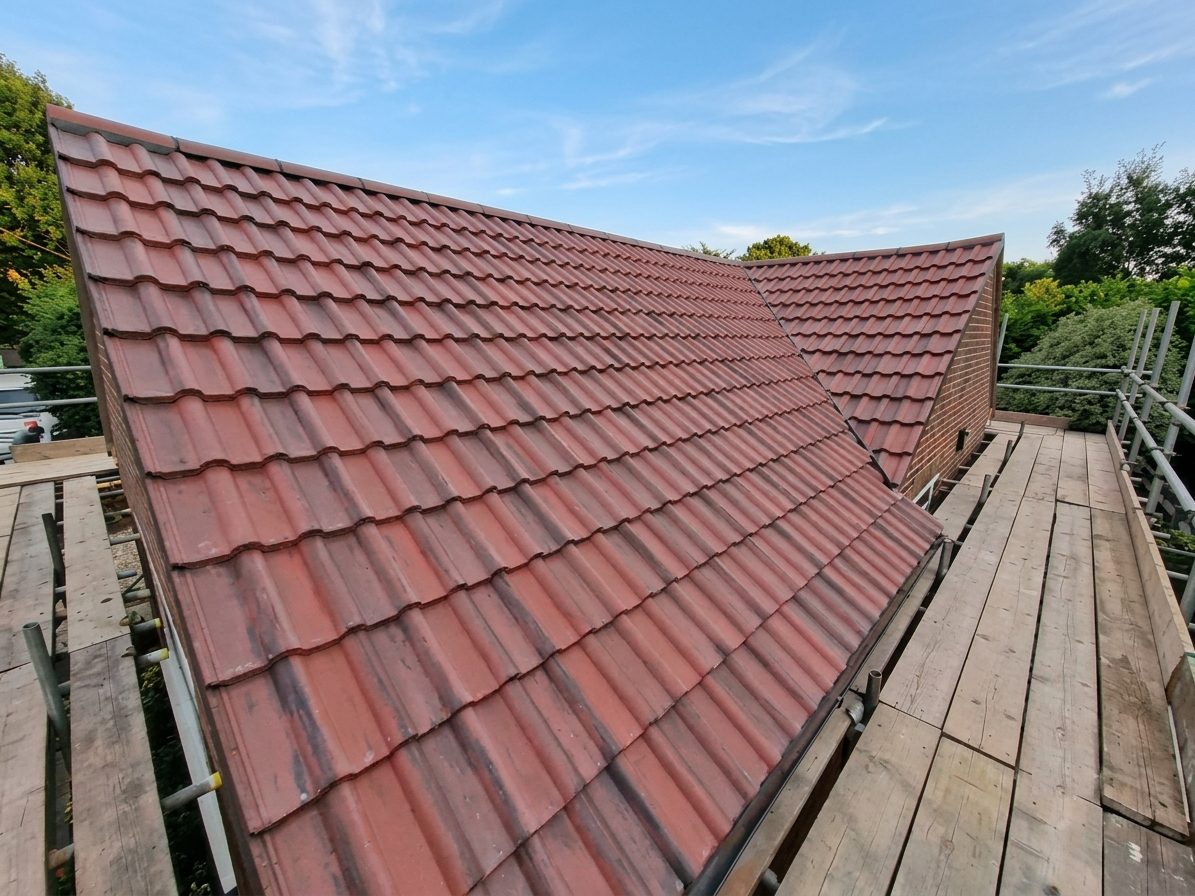 Newly completed red clay tile re-roof with scaffolding on a Yorkshire home by AC Roofing & Guttering