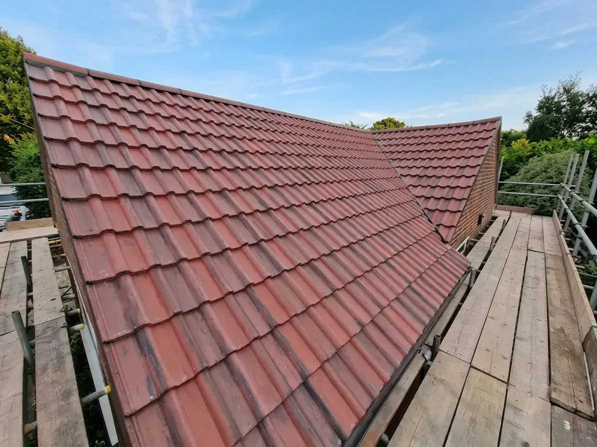 Newly completed red clay tile re-roof with scaffolding on a Yorkshire home by AC Roofing & Guttering